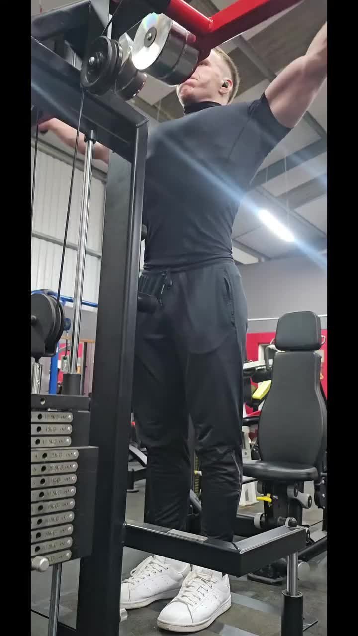 A member training on a machine on the gym floor in the evening